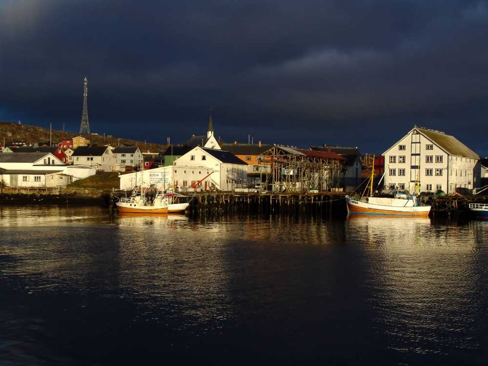 Das Fischerdorf Berlevag im Abendsonnenlicht und drohendem Unwetter: 70.85805069197879, 29.0861208559177 